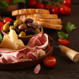 Italian food, prosciutto, olives, cheese and tomatoes